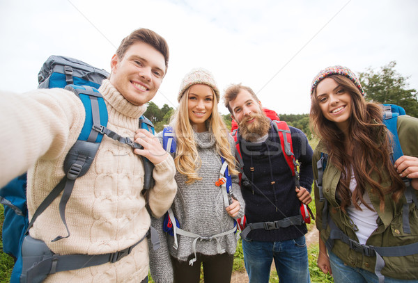 group of smiling friends with backpacks hiking Stock photo © dolgachov