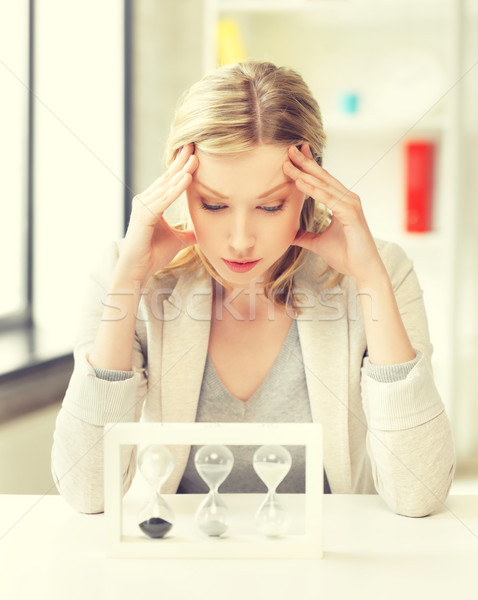 tired woman behind the table with hourgalss Stock photo © dolgachov