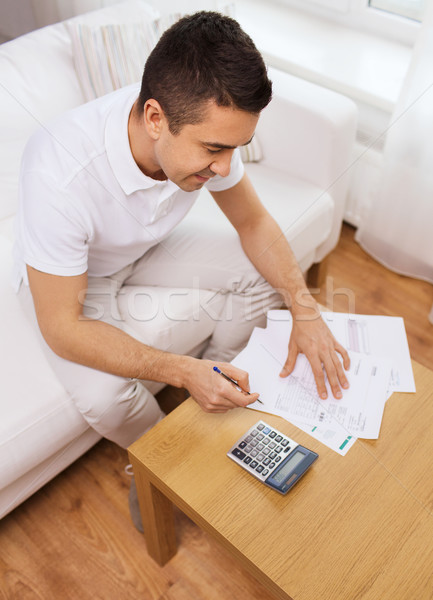 man with papers and calculator at home Stock photo © dolgachov