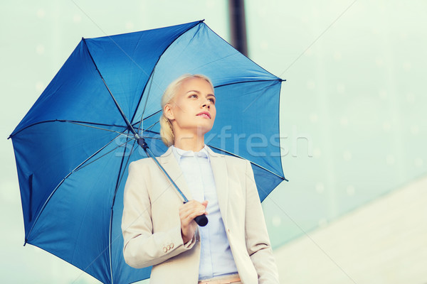young serious businesswoman with umbrella outdoors Stock photo © dolgachov