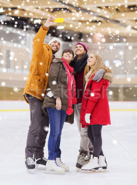 Stock photo: happy friends taking selfie on skating rink