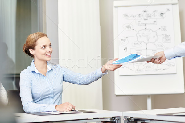 businesswoman taking papers from someone in office Stock photo © dolgachov