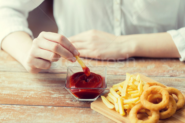 close up of hand dipping french fries into ketchup Stock photo © dolgachov