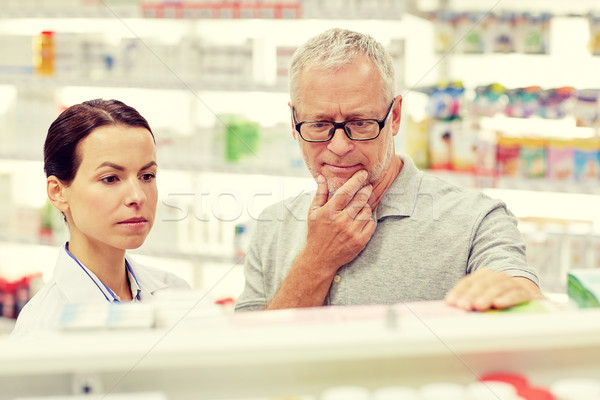 Gyógyszerész mutat drog idős férfi gyógyszertár Stock fotó © dolgachov