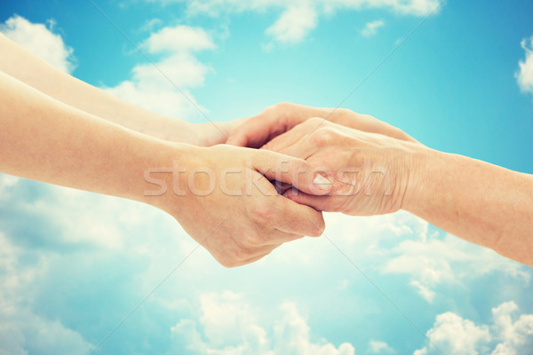 close up of senior and young woman holding hands Stock photo © dolgachov