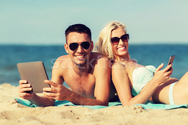 happy couple with tablet pc sunbathing on beach Stock photo © dolgachov