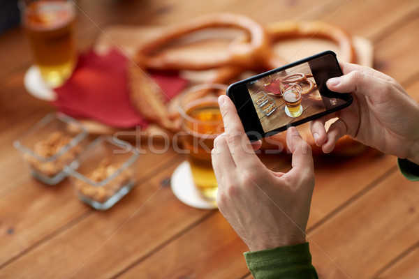 close up of hands with smartphone picturing beer Stock photo © dolgachov