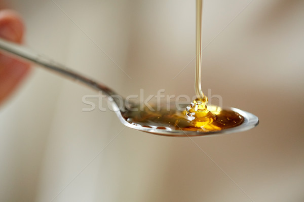 close up of honey pouring to teaspoon Stock photo © dolgachov