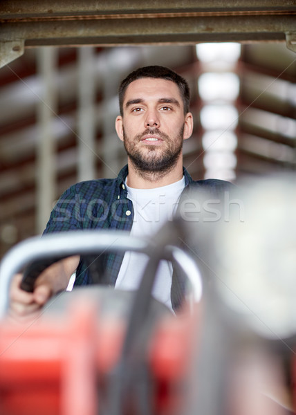 man or farmer driving tractor at farm Stock photo © dolgachov