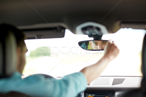 man driving car adjusting rearview mirror Stock photo © dolgachov