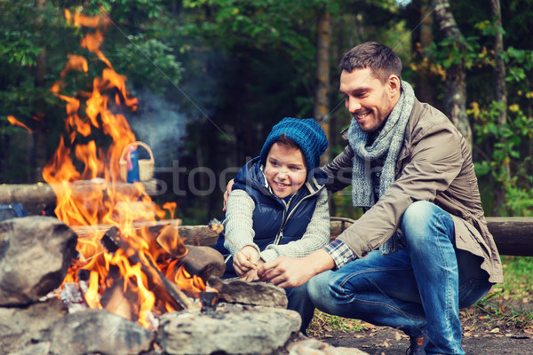 father and son roasting marshmallow over campfire Stock photo © dolgachov