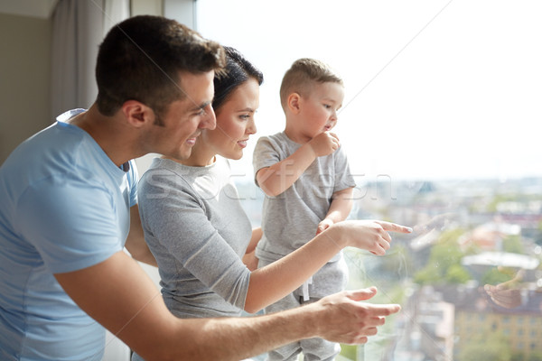 Famille heureuse regarder fenêtre maison personnes famille [[stock_photo]] © dolgachov