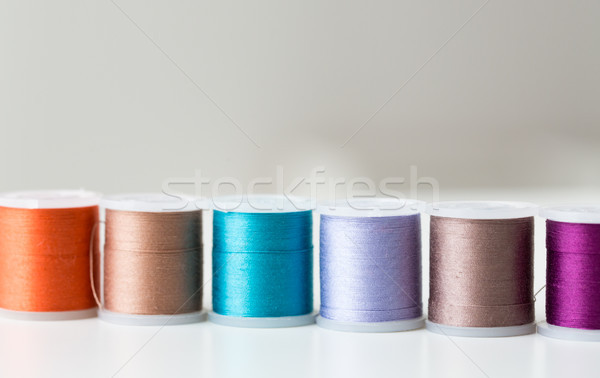 row of colorful thread spools on table Stock photo © dolgachov