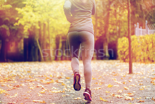 close up of young woman running in autumn park Stock photo © dolgachov