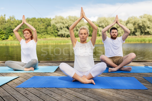 people meditating in yoga lotus pose outdoors Stock photo © dolgachov