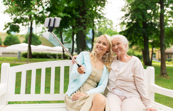 daughter and senior mother taking selfie at park Stock photo © dolgachov