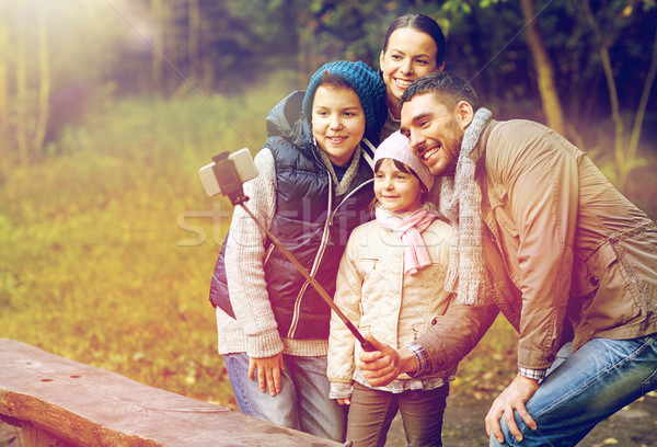 Stock photo: happy family with smartphone selfie stick at camp