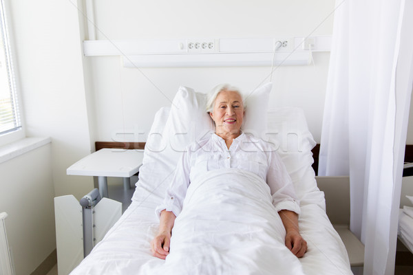 smiling senior woman lying on bed at hospital ward Stock photo © dolgachov