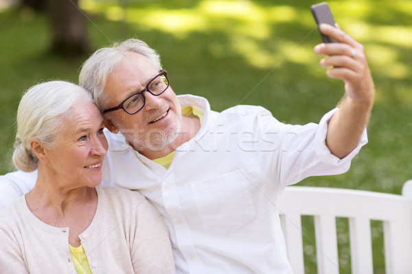 senior couple taking selfie by smartphone at park Stock photo © dolgachov