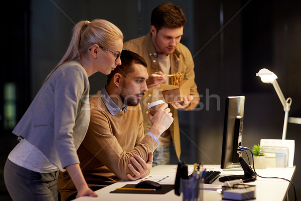 business team with computer working late at office Stock photo © dolgachov
