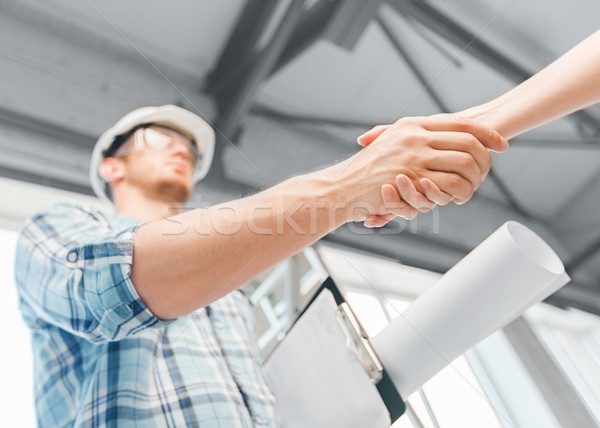 builder with blueprint shaking partner hand Stock photo © dolgachov
