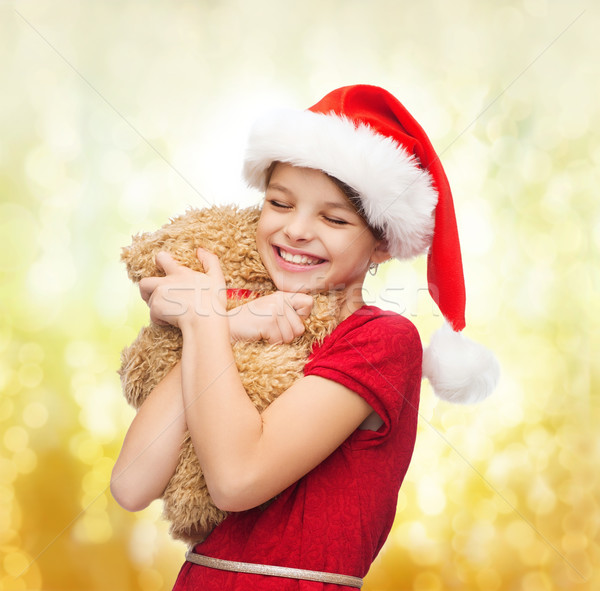 smiling girl in santa helper hat with teddy bear Stock photo © dolgachov