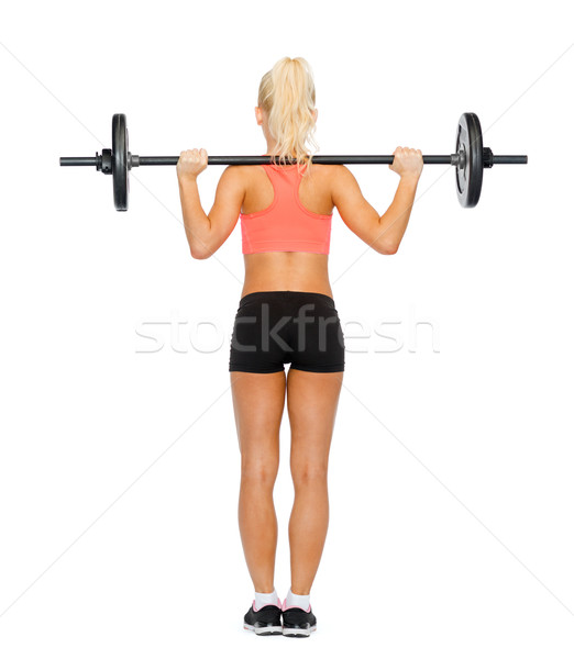 sporty woman exercising with barbell from the back Stock photo © dolgachov