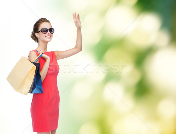 smiling elegant woman in dress with shopping bags Stock photo © dolgachov