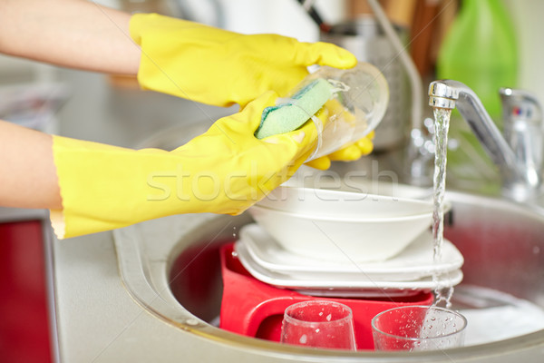 Stock photo: close up of woman hands washing dishes in kitchen