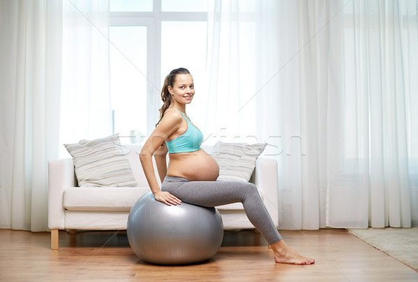 happy pregnant woman exercising on fitball at home Stock photo © dolgachov