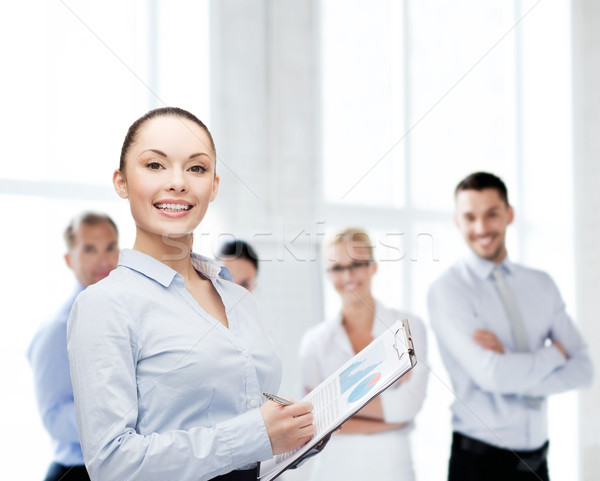 Jeunes souriant femme d'affaires presse-papiers stylo affaires [[stock_photo]] © dolgachov