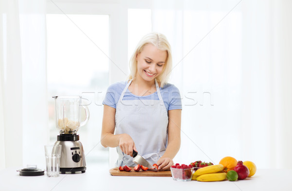 Stock photo: smiling woman with blender preparing shake at home