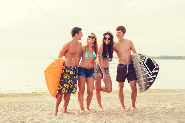 smiling friends in sunglasses with surfs on beach Stock photo © dolgachov
