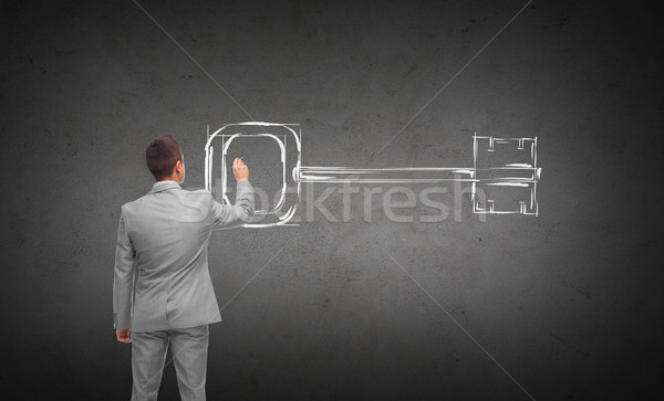 businessman drawing key from back Stock photo © dolgachov