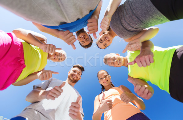 group of happy sporty friends showing thumbs up Stock photo © dolgachov