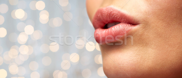 close up of young woman lips over holidays lights Stock photo © dolgachov