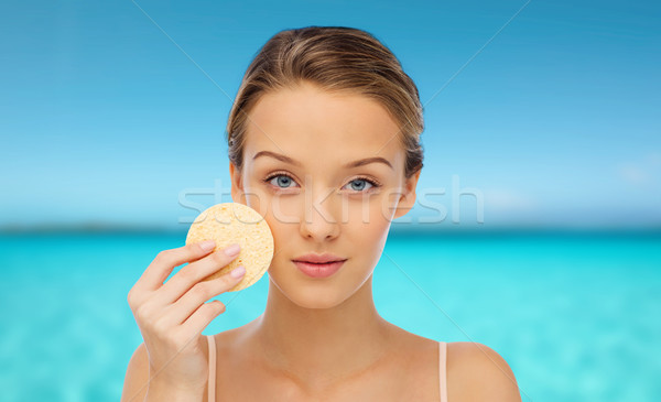 young woman cleaning face with exfoliating sponge Stock photo © dolgachov