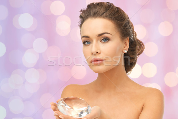 Stock photo: woman showing big diamond over pink lights