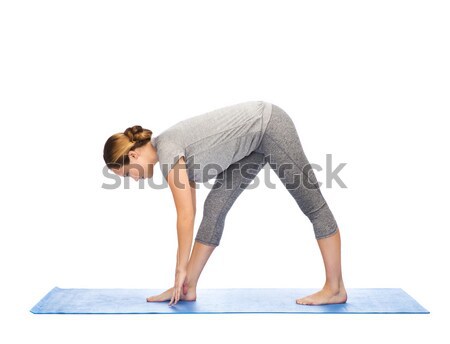 woman making yoga intense stretch pose on mat Stock photo © dolgachov