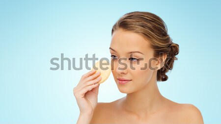 young woman cleaning face with exfoliating sponge Stock photo © dolgachov