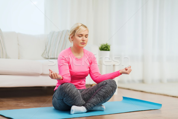 happy woman stretching leg on mat at home Stock photo © dolgachov