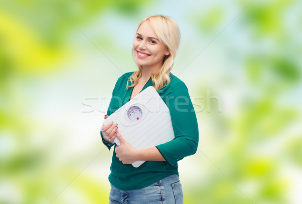 smiling young woman holding scales Stock photo © dolgachov
