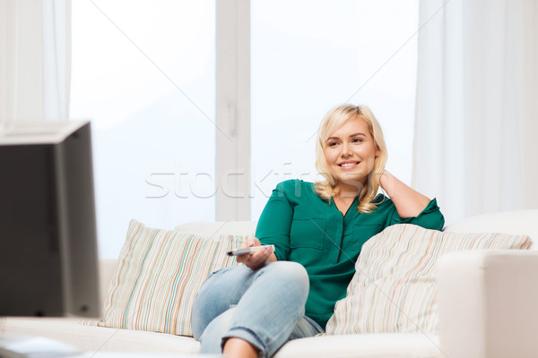 smiling woman with remote watching tv at home Stock photo © dolgachov