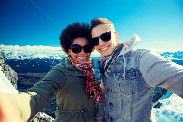 happy teenage couple taking selfie over mountains Stock photo © dolgachov