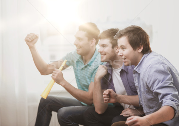 happy male friends with vuvuzela watching sports Stock photo © dolgachov