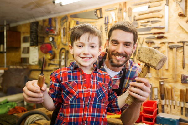 boy with dad holding chisel and hammer at workshop Stock photo © dolgachov