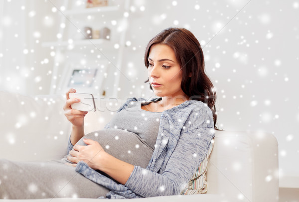 sad pregnant woman with smartphone at home Stock photo © dolgachov