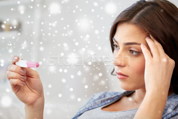 sad woman looking at home pregnancy test Stock photo © dolgachov