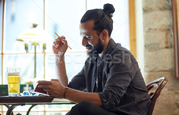 close up of man with beer and notebook at pub Stock photo © dolgachov