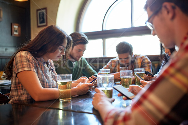 Stockfoto: Vrienden · smartphones · bier · bar · pub · mensen